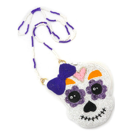 Sugar skull handbag with purple bow and colorful accents on a white background